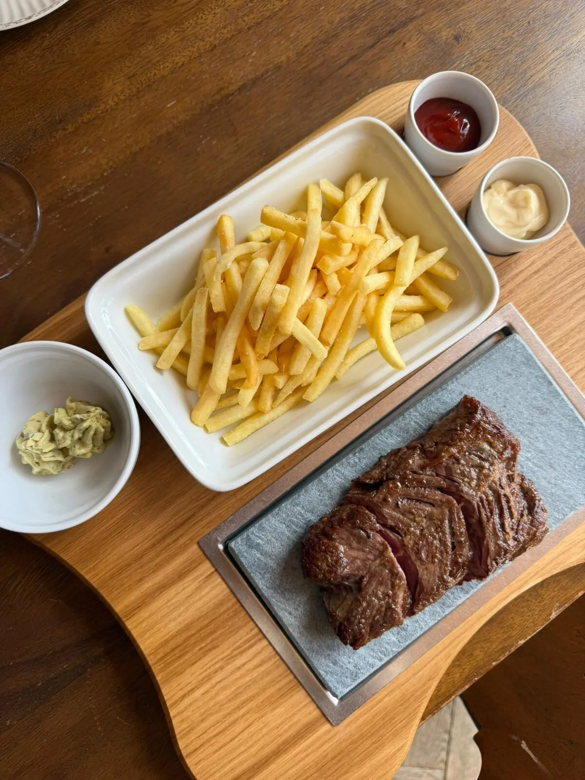Rindsentrecôte auf dem heissen Stein mit Pommes frites und Kräuterbutter
