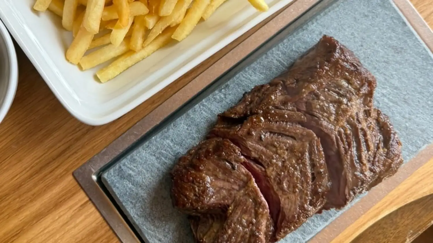 Rindsentrecote auf heissem Stein, mit Pommes frites und Kraeuterbutter